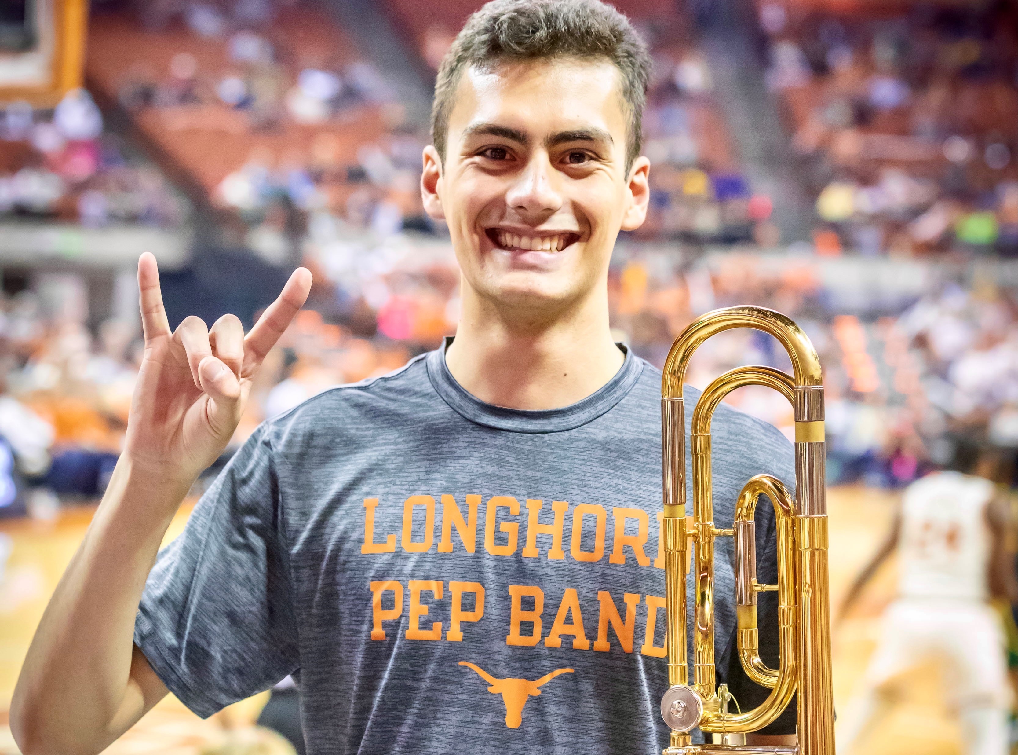 Atilano Garcia performing with the pep band, showcasing musical talents and university involvement